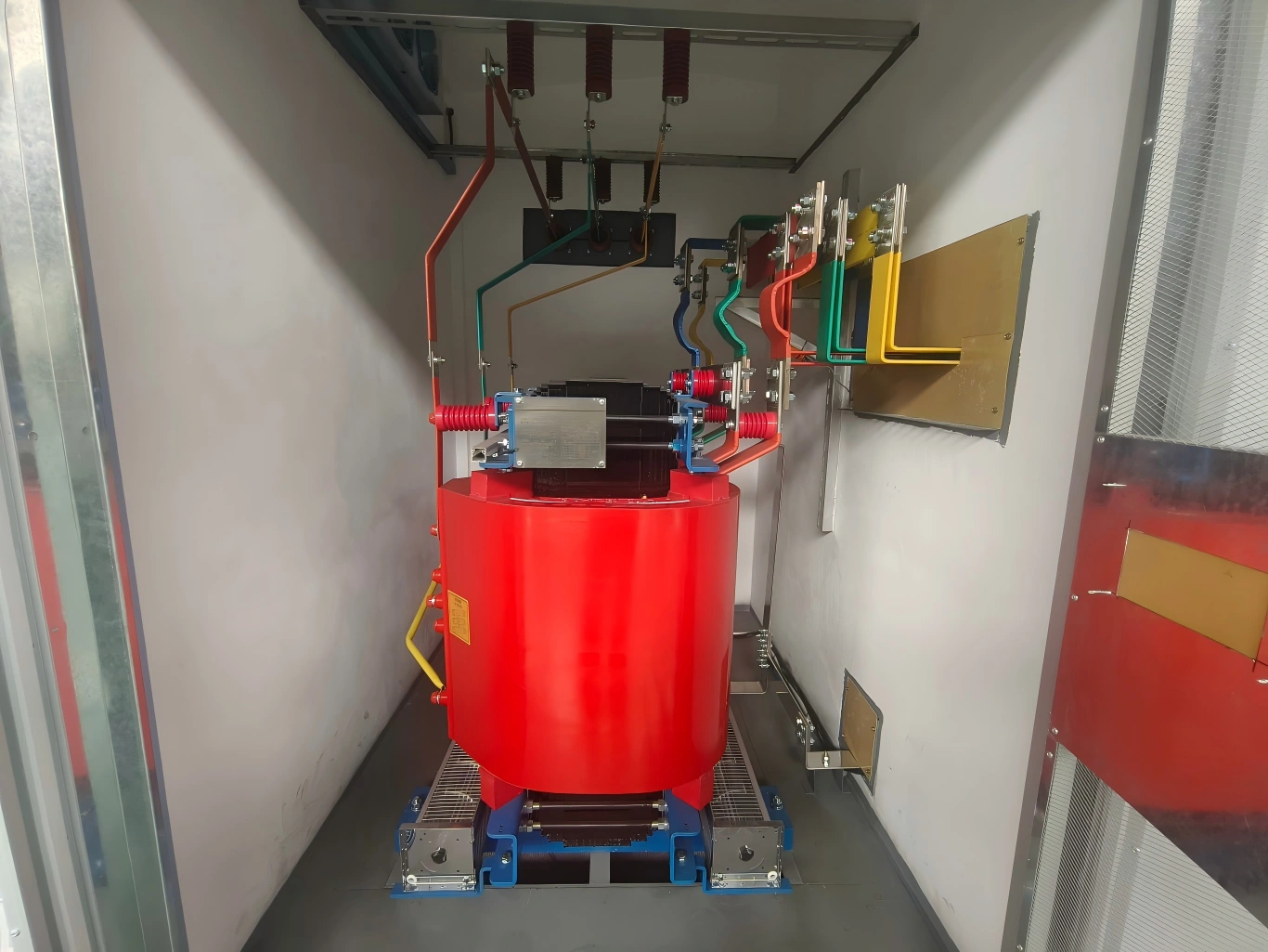 Dry-type cast resin transformer connected with color-coded busbars and HV surge arresters in a box-type substation