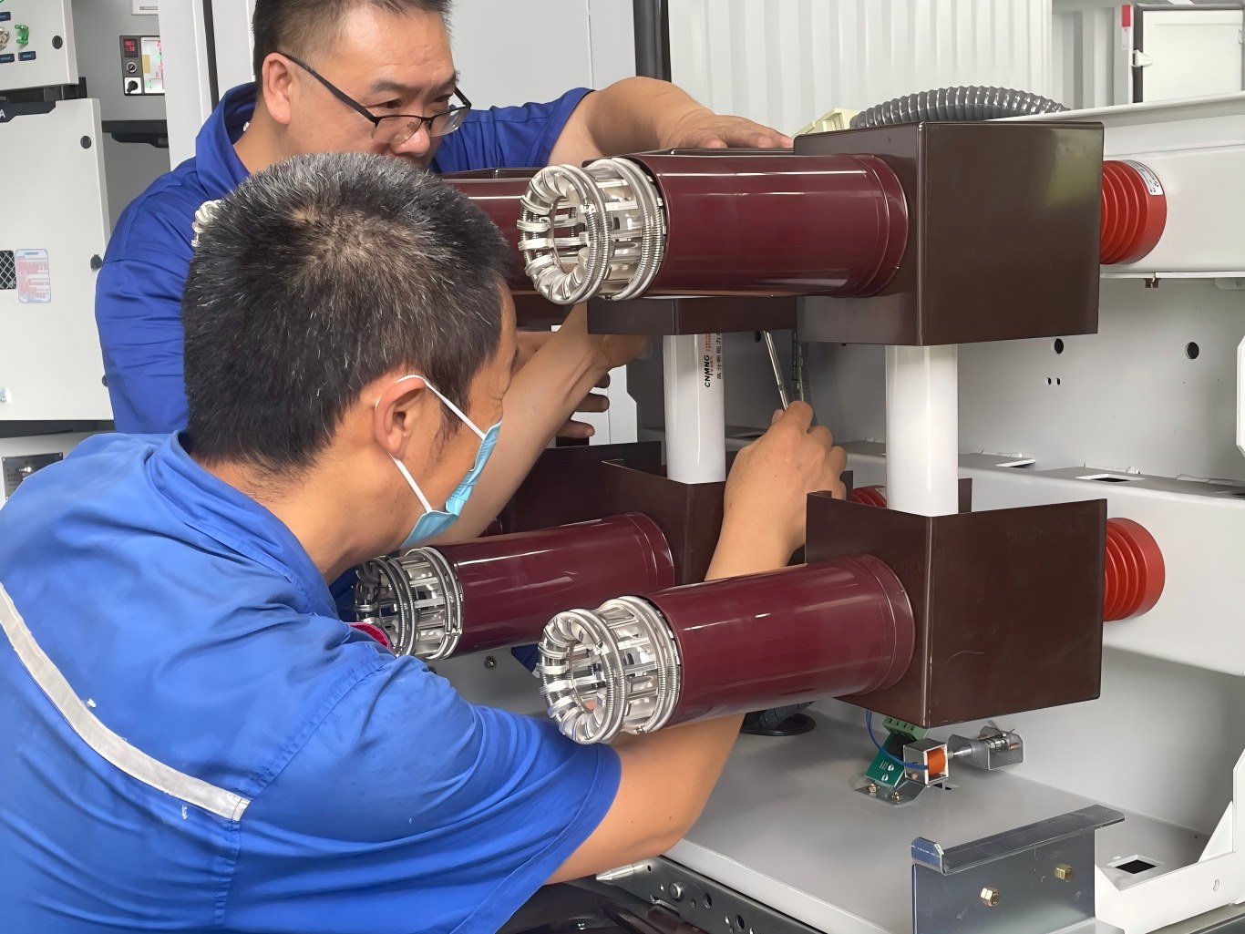 Engineers assemble contact bushings for medium voltage switch cabinet