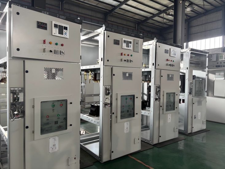 Metal enclosed switchgear cabinets with open doors showing internal busbars and circuit breakers during assembly