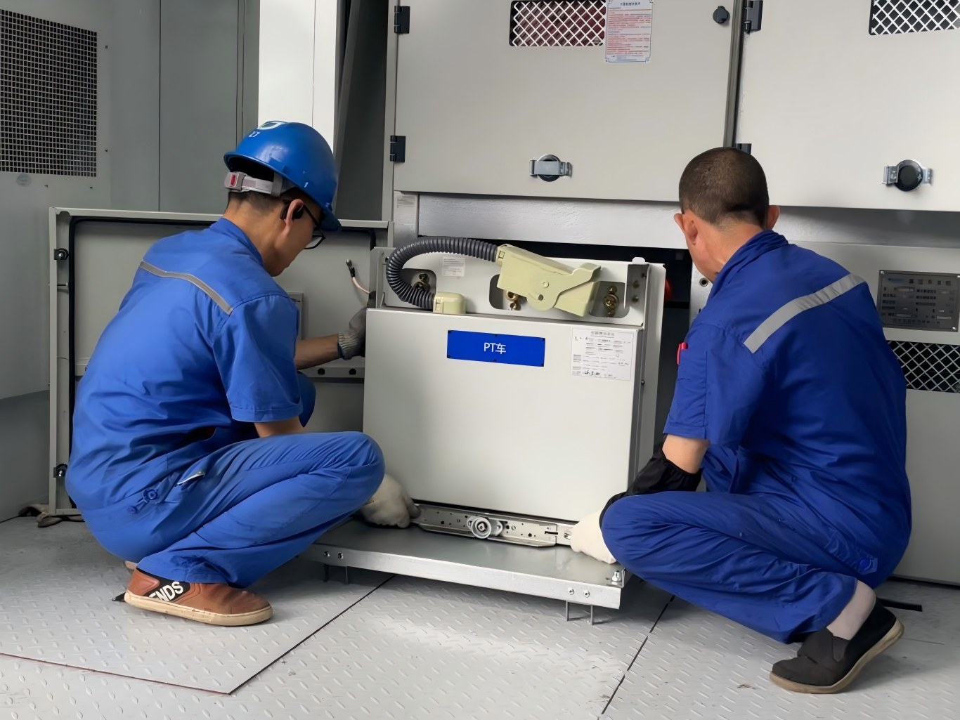 Two technicians install PT trolley inside KYN28A-12 switch cabinet