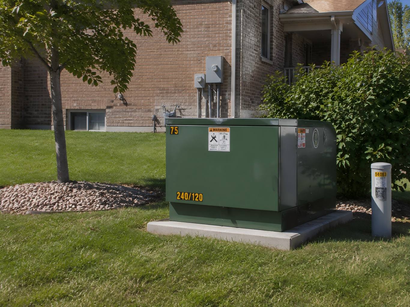 a green single-phase pad-mounted transformer in a residential neighborhood