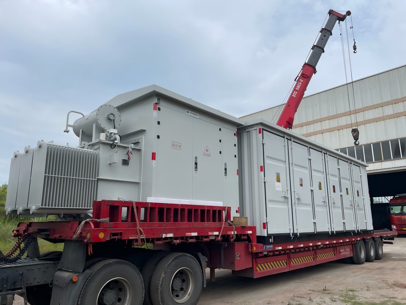 Complete containerized power substation loaded on flatbed truck for delivery