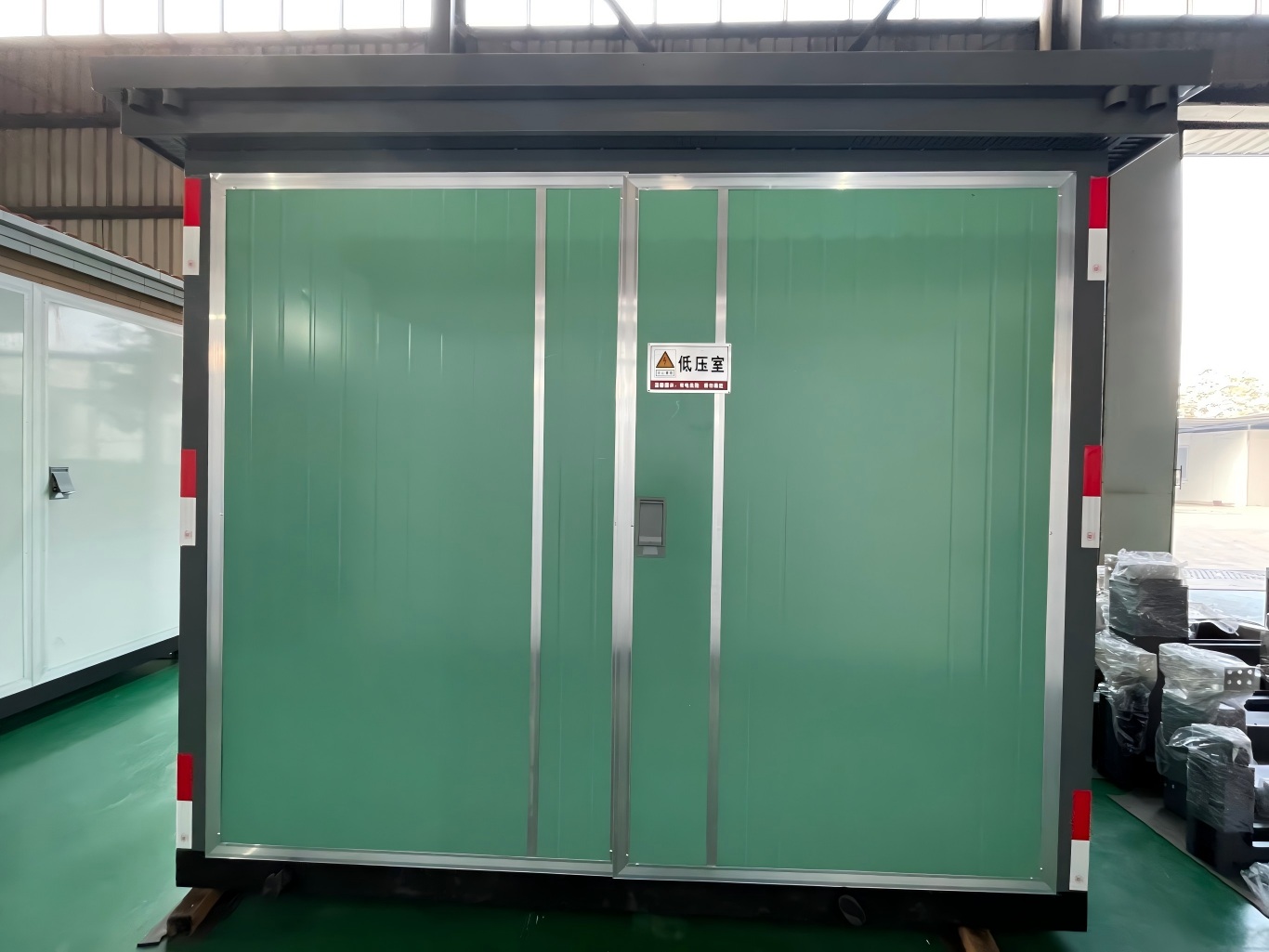Metallic green prefabricated substation in the workshop
