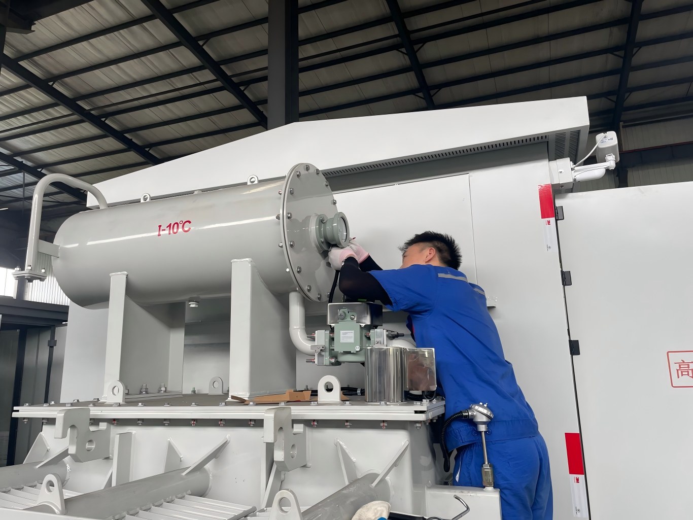 Worker assembles oil immersed transformer in factory workshop