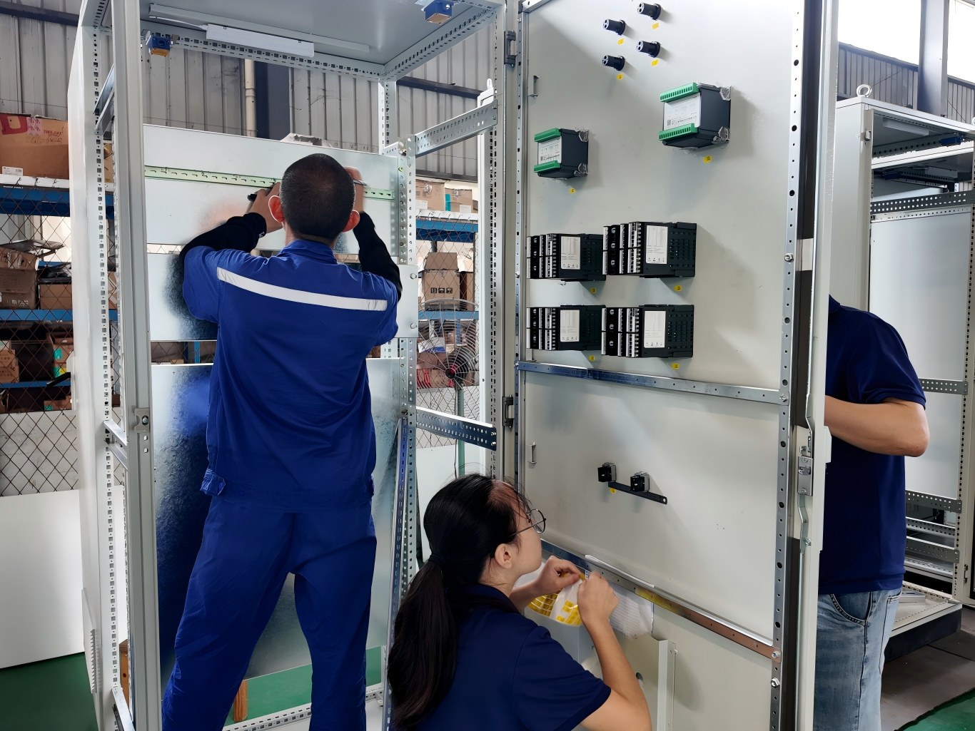 workers install components on temperature control cabinet